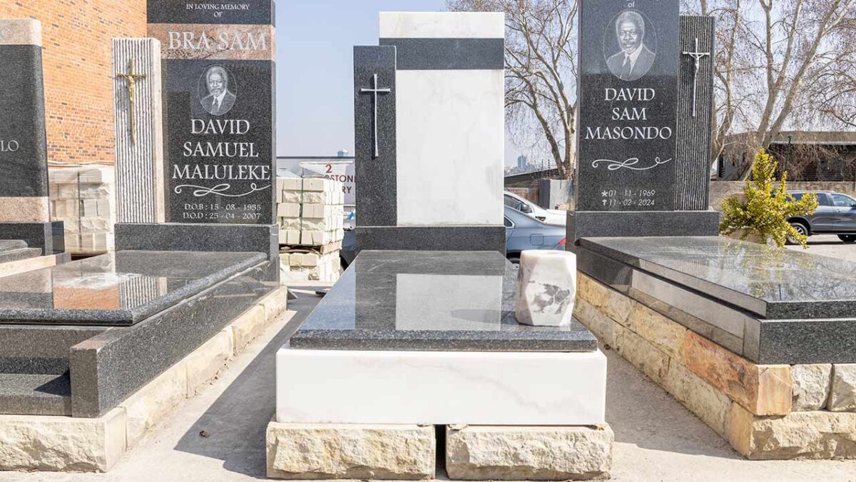 Artisan polishing a newly carved granite headstone in the Tombstone Factory workshop