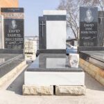 Artisan polishing a newly carved granite headstone in the Tombstone Factory workshop