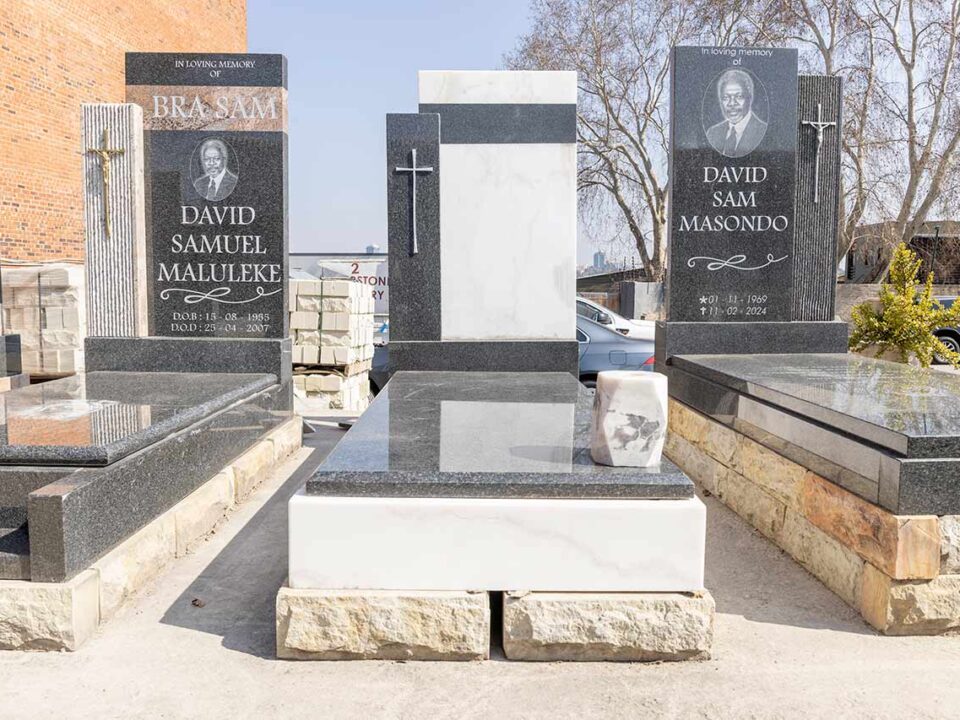 Artisan polishing a newly carved granite headstone in the Tombstone Factory workshop