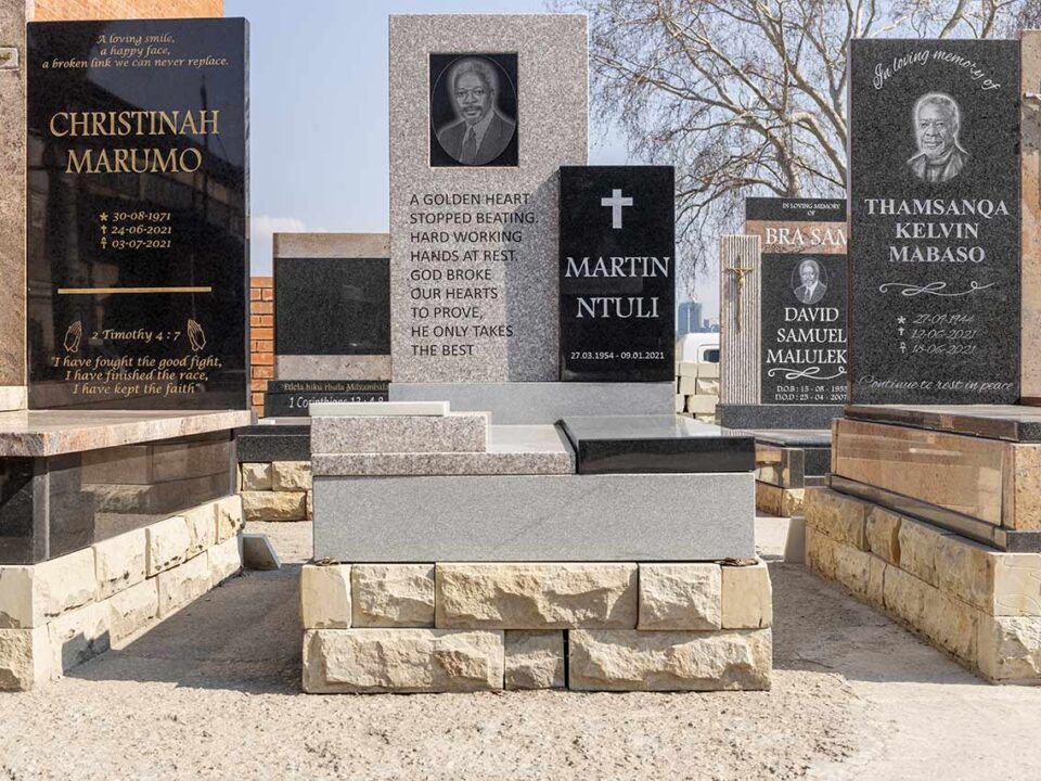 Customer viewing granite tombstone designs with consultant at Tombstone Factory showroom