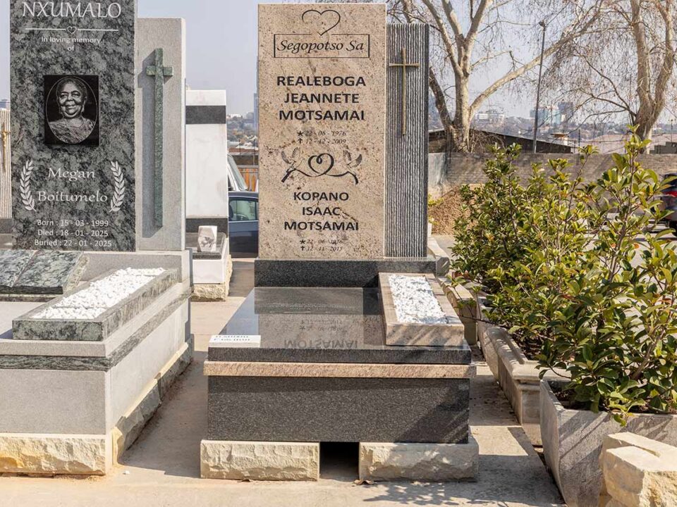 Close-up of granite tombstone with matching vase and engraved plaque