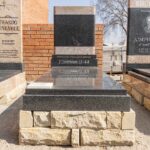 Family placing flowers at a granite tombstone during a peaceful memorial visit