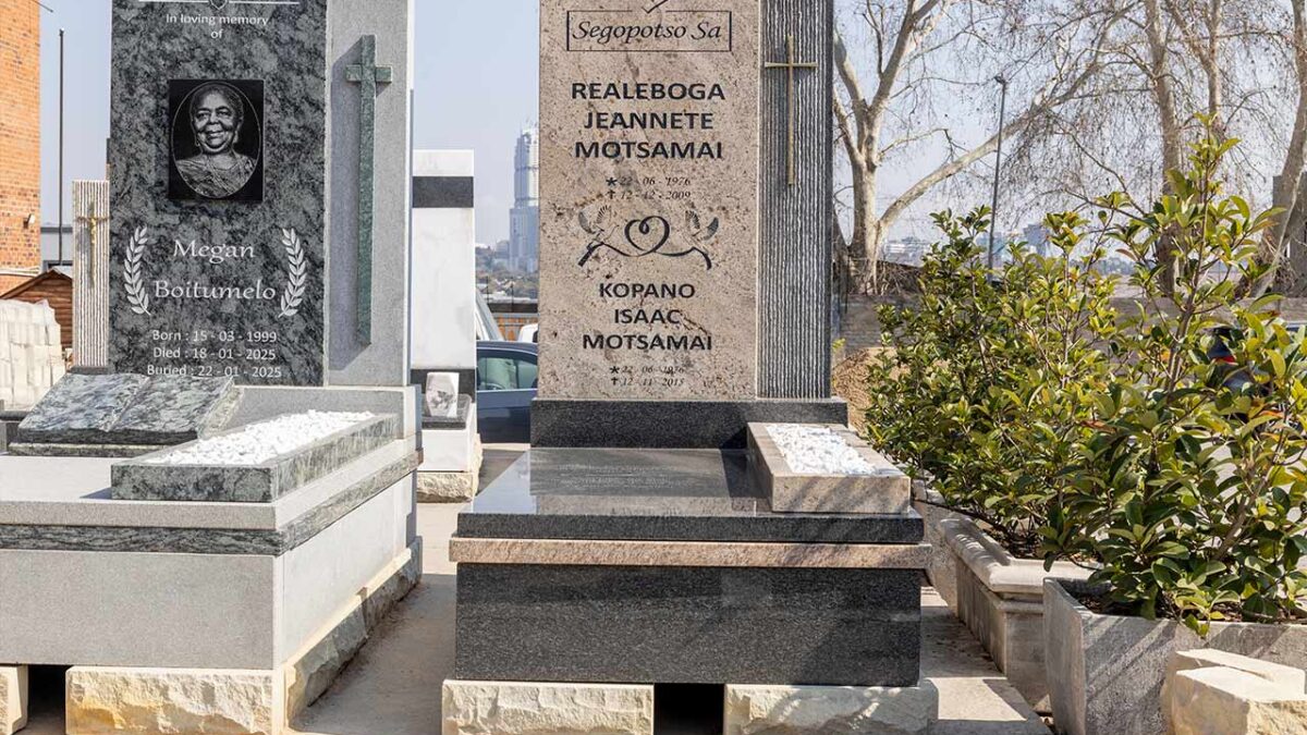 Restoration expert re-lettering an old granite tombstone in Johannesburg
