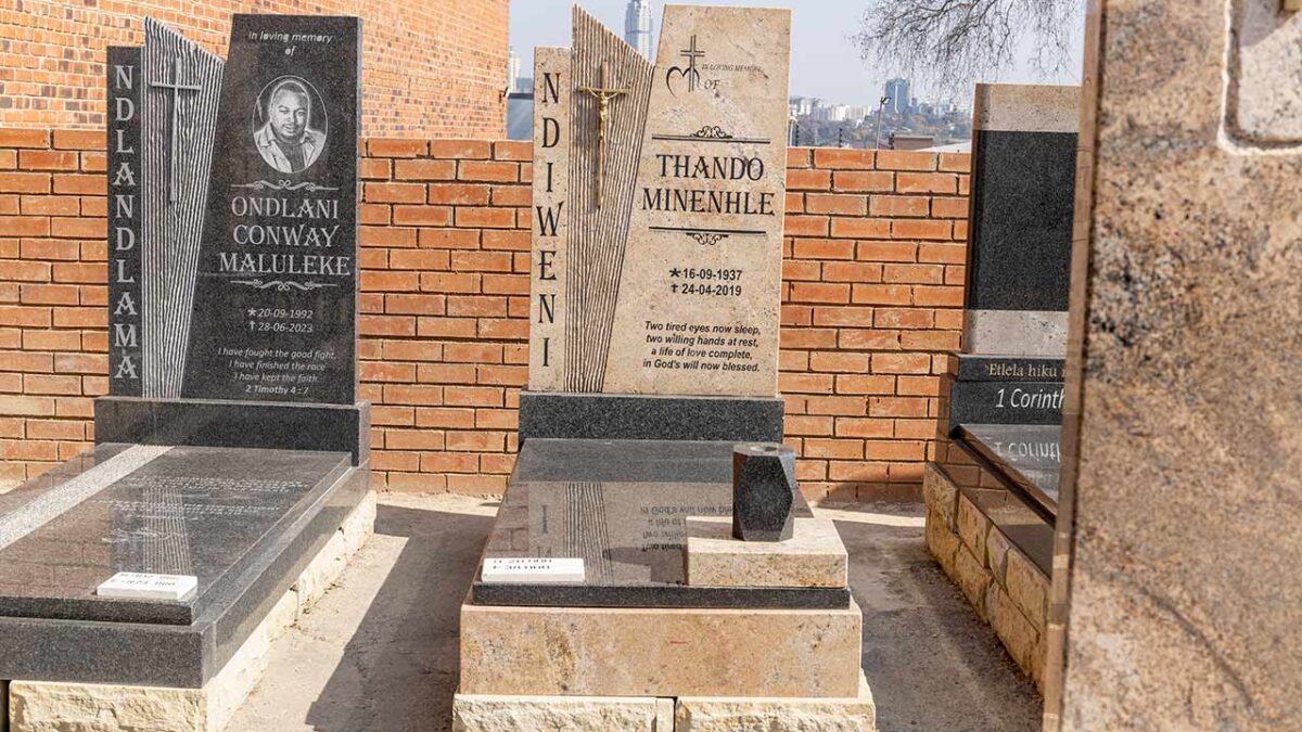 Close-up of angel and cross carvings on a granite tombstone in South Africa